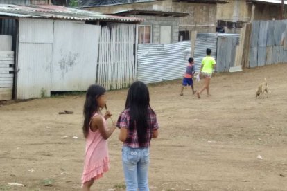 Una niña recibe clases en casa de la mano de su madre. Su hogar no cuenta con Internet.