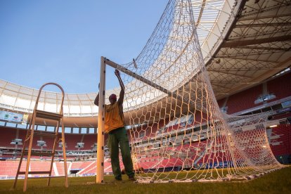 Un empleado trabaja, en el campo del estadio Mané Garrincha que acogerá la inauguración de la Copa América en la ciudad de Brasilia.
