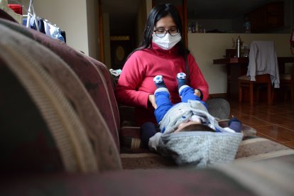 La madre del bebé lo ayuda con terapias físicas para que pueda mover sus músculos.