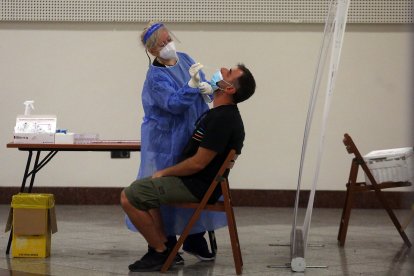 Un hombre es examinado para detectar la enfermedad por coronavirus (COVID-19) en la estación de metro Syntagma en el centro de Atenas, Grecia.