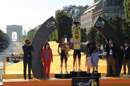Richard Carapaz (d) en el podio del Tour de Francia. El ciclista ecuatoriano recibió el premio al tercer lugar  junto a sus hijos.