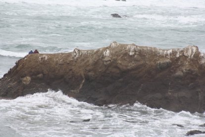 Los dos turistas se ubicaron en la punta del islote que estaba rodeado de agua.