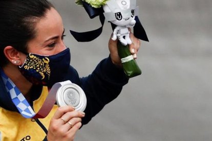 La ciclista colombiana sonríe frente a las cámaras con su medallas ganada.