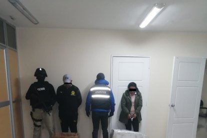 Los dos detenidos junto a los policías y la droga incautada en una casa de Tulcán.