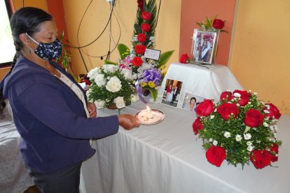 Rosa Muy ora frente a un altar donde están varias fotos de su sobrina Nohemí.
