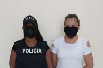 La sospechosa arrestada por extorsión, junto a una agente de la Policía.