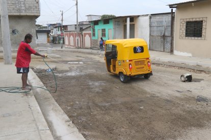 Clemente Hallay moja la calle para que no se levante la polvareda.