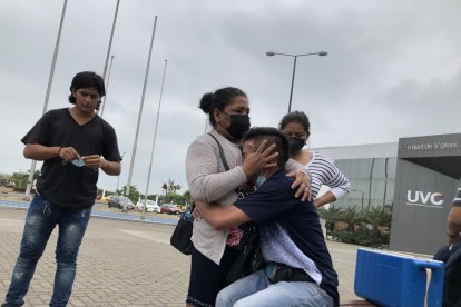 La víctima de asalto a mano armada llora mientras sus familiares tratan de consolarlo.