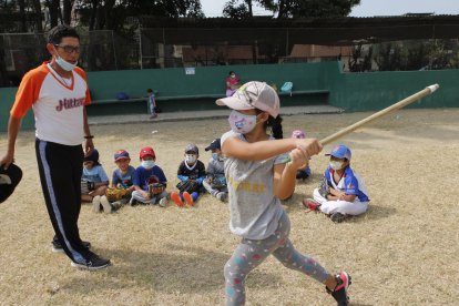 Con palos de escoba como bates aprenden los movimientos.