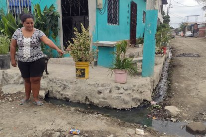 Una moradora muestra la presencia de las aguas residuales en las calles.