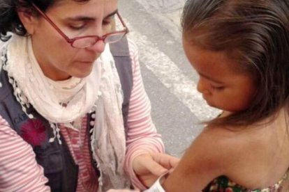 Una activista realizar una valoración médica a una niña.
