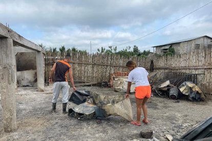La afectada escarba en los escombros buscando algo que sirva.