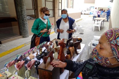 Visitantes observan las artesanías de una de las emprendedoras.