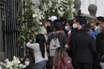 Transeúntes se apuraban para coger los arreglos florales.
