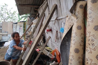 Sofía acomoda los palos que sostienen la pared de su ‘caleta’ de caña.