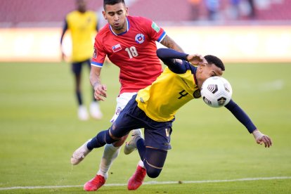 Byron Castillo de Ecuador mientras disputa un balón con Sebastián Vegas de Chile.