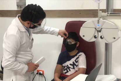 El optometrista Tito Picón en la consulta con el pequeño Antony, quien llegó con problemas de visión borrosa.