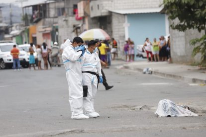 Personal de Criminalística en la escena del crimen, junto al cadáver.