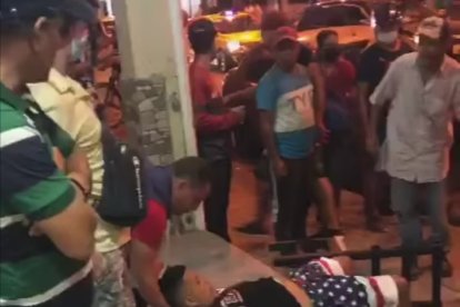 Uno de los heridos cuando era ayudado por varias personas tras el ataque.