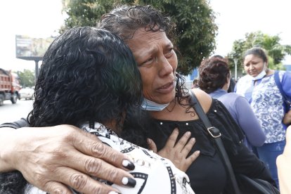 Isabel Conde Martínez viajó desde Milagro para retirar los cadáveres de sus dos hijos. Sus familiares le dan consuelo.