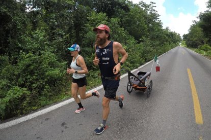 El atleta alemán Jonas Deichmann (d) corre con destino al poblado de Santo Domingo en Cancún, estado de Quintana Roo (México).