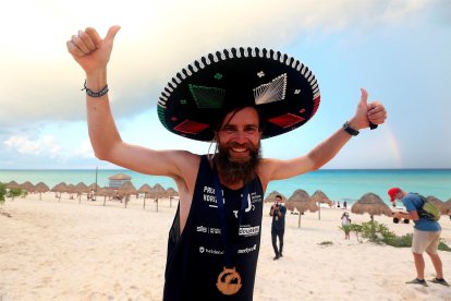 El atleta Jonas Deichmann celebra su llegada hoy, a la zona turística del balneario de Cancún, en el estado de Quintana Roo (México).