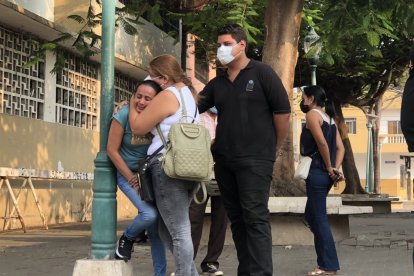 Familiares del occiso se abrazan y lloran desconsoladamente fuera de la morgue.