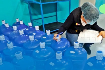 Una inspectora de Arcsa realizando las inspecciones en una planta embotelladora.