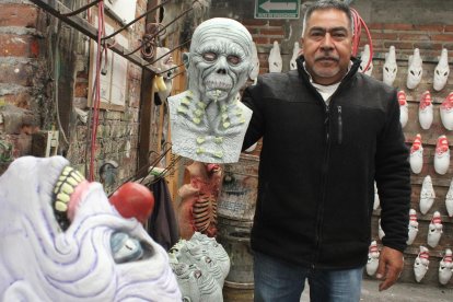 Rafael Domínguez González, fundador del taller Mastermanía, muestra una máscara para Día de Muertos