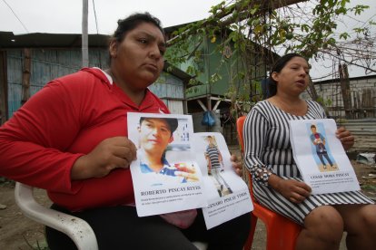 Olimpia Cruz y Mireya Pincay  muestran las hojas impresas con los rostros de sus seres queridos. Piden ayuda a la Policía y a la ciudadanía.