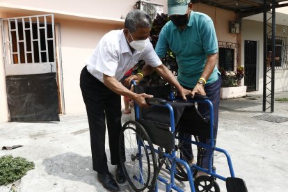 Juan entrega a Douglas la silla de ruedas. Al adulto mayor le complace saber que Ivis es cuidada con amor por su hijo.