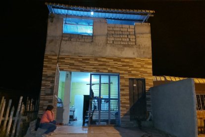 Una mujer pensativa fuera de la casa que fue tiroteada presuntamente por un prestamista.