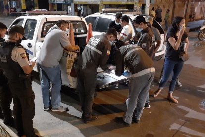 Los agentes analizan el arma que se le cayó al sospechoso.