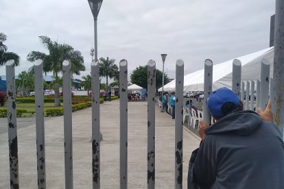 Entre los barrotes de la morgue policial, Juan asoma su cabeza esperando tener noticias de su familiar.