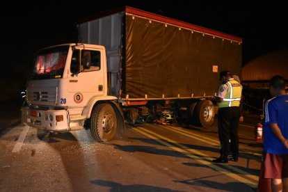 A los agentes se les dificultó levantar el cadáver, porque estaba atrapado entre las llantas.