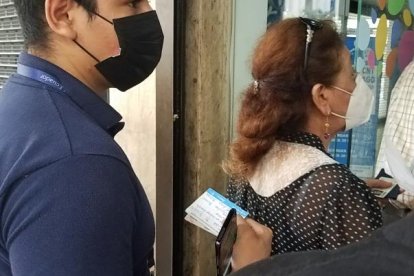 Con su carnet de vacunación a la mano, un ciudadano espera su turno para ingresar a una entidad pública para realizar un trámite.