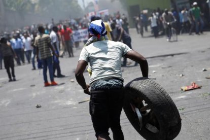 Referencial. Un manifestante porta un neumático durante una manifestación contra el gobierno del presidente Jovenel Moise en las calles de Puerto Príncipe, Haití,