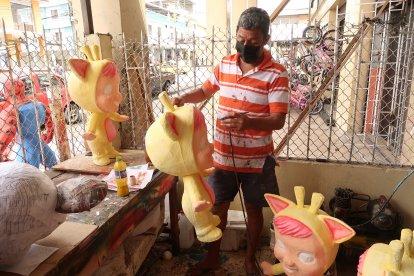 Tradicional. Carlos González continuaba ayer la pintada de pequeños muñecos tradicionales, que también son vendidos por su bajo precio.