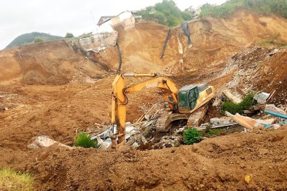 Maquinaria pesada realiza la limpieza de material y escombros en el barrio hundido de Chimbo