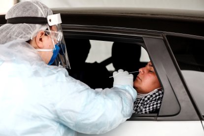 Un trabajador sanitario muestra una prueba de diagnóstico de COVID-19, cuya demanda ha crecido por la presencia de la variante ómicron.