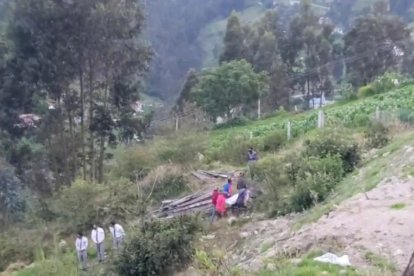 Momento en que sacaban los cuerpos de la madre y sus niños del predio, en una zona rural de Cuenca.