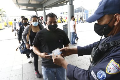 Guardias y personal administrativo de la Metrovía revisa el carné de vacunación en el ingreso a uno de los paraderos del servicio.