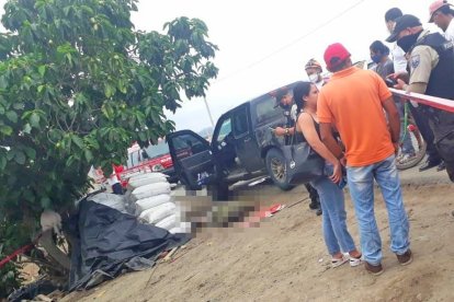 El cuerpo tendido del hombre junto a su camioneta.