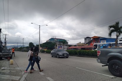 Con cuidado los peatones cruzan la vía en la cual circulan buses, camiones, etcétera.