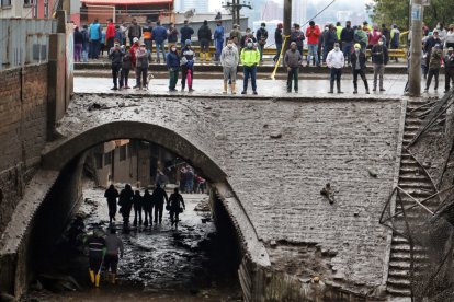 Rescatistas y decenas de moradores miran el desastre causado por el aluvión el 31 de enero.