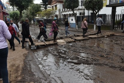 En la calle Luis Cordero la gente tuvo que improvisar un puente para poder cruzar de extremo a extremo.