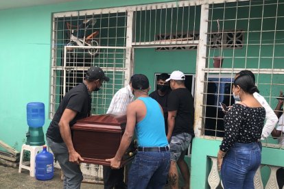 El cofre mortuario con los restos de la mujer fallecida es ingresado a su casa para el velatorio.