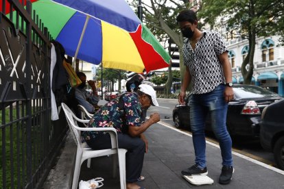 Enrique dando indicaciones de cómo usar la balanza a sus usuarios. Quedan pocas personas dedicadas a esta actividad en el centro de la urbe porteña.