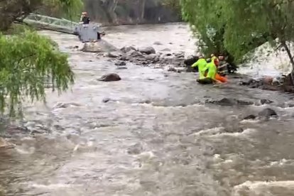 Rescatistas en acción para sacar el cuerpo del joven de las aguas del Tomebamba.