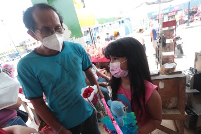 Ana Dávila junto a su padre comprando un detalle para la madre de la niña.